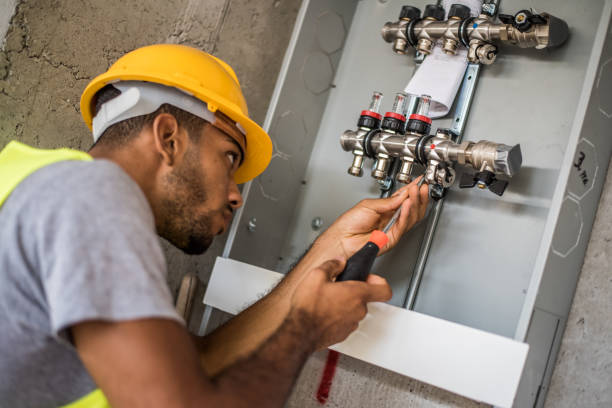 Construction worker configuring water valves stock photo