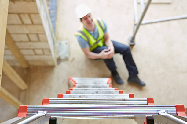 Construction Worker Falling Off Ladder And Injuring Leg stock photo