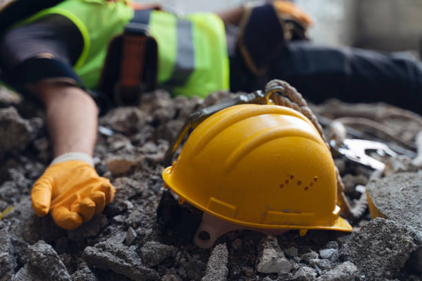 Construction worker has an accident while working on new house. Construction worker lies on the floor at the work site. Work accident stock photo