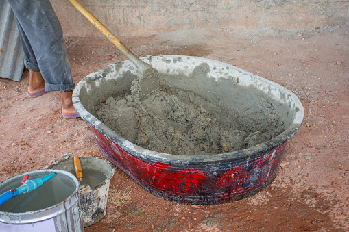 Construction Worker Manually Mixing Concrete In Mixer Tray Stock Photo