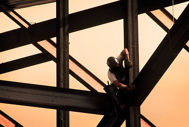 construction worker on high rise frame of building - girder stockfoto's en -beelden