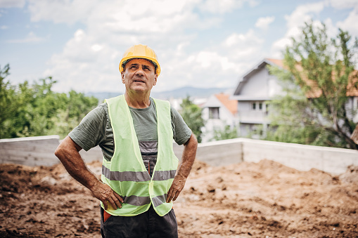 Portrait of a mature male construction worker standing at the construction site.