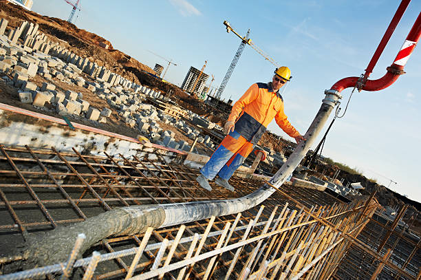 Construction worker pouring concrete on a job site  stock photo