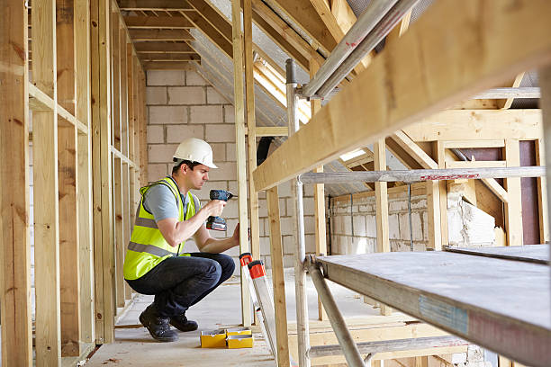 Construction Worker Using Drill On House Build stock photo