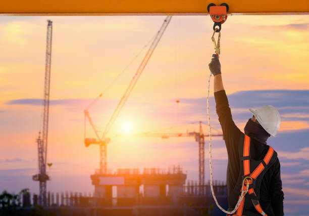 Construction worker wearing safety harness. Construction worker wearing safety harness and safety line working high place at industrial. high up stock pictures, royalty-free photos & images