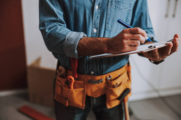 Construction worker writing on clipboard stock photo Close up of a repairman standing and making notes tool belt stock pictures, royalty-free photos & images