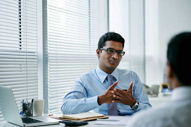 Consulting coworker Handsome young businessman talking to his colleague culture of india stock pictures, royalty-free photos & images