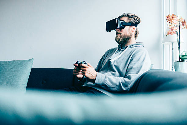 Consumer wears VR glasses and plays game at home stock photo