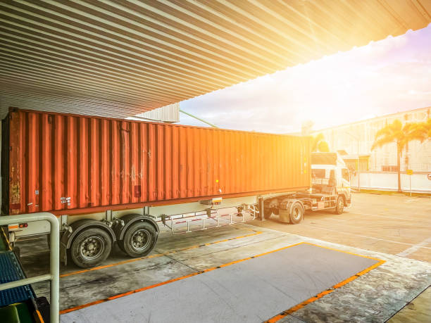 Container trucks delivering, receiving station and transportation truck. stock photo