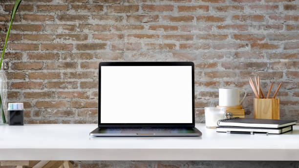Contemporary workspace with blank screen laptop on white wood table. Contemporary workspace with blank screen laptop on white wood table. blank screen stock pictures, royalty-free photos & images