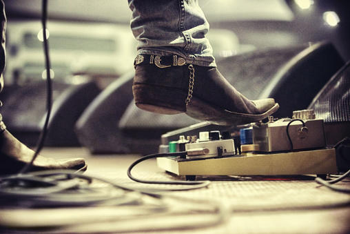 Cropped shot of a music artist's foot on a foot pedal. This concert was created for the sole purpose of this photo shoot, featuring 300 models and 3 live bands. All people in this shoot are model released.