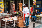 Istanbul, Turkey - June 8 2014: Cook Cutting Meat From a Doner Kebab for a Customer in a Turkish Street Food Restaurant.