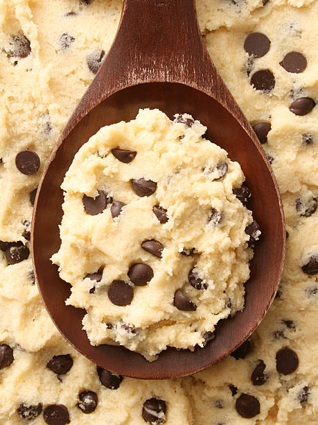 Cookie dough Top view of wooden spoon full of cookie dough with chocolate chips for baking dough stock pictures, royalty-free photos & images