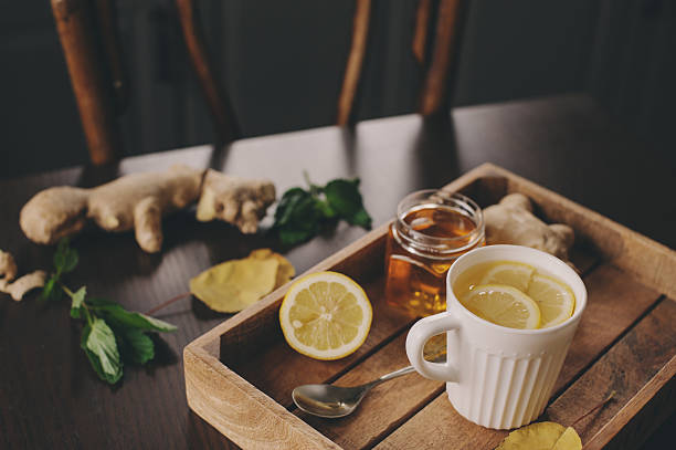 cooking ginger, lemon and honey tea in dark rustic interior stock photo