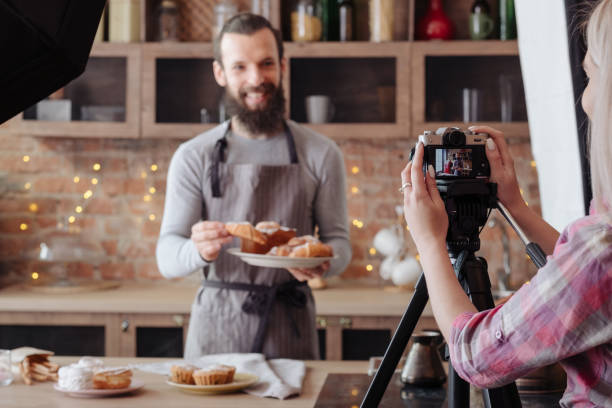cooking man baking chef backstage photography Cooking man. Baking. Excited chef in apron with plate of fresh cakes and pastries. Backstage photography. commercial photographers stock pictures, royalty-free photos & images