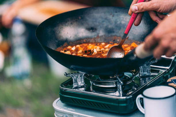 Cooking on the Move – Van Life Diaries Cooking on the Move – Van Life Diaries: Cooking in a Curry in a Wok Pan camping stove stock pictures, royalty-free photos & images