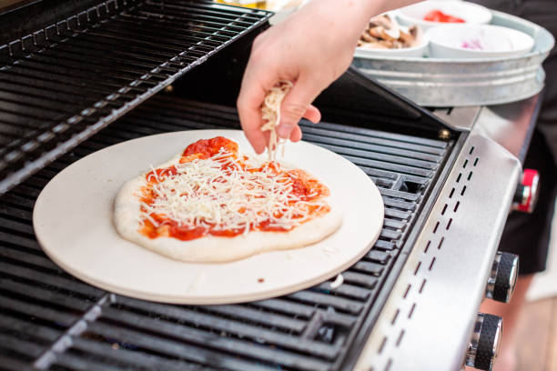 Cooking pizza on outdoor gas grill. stock photo