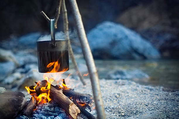 cooking pot above camp fire "cooking pot hanging above camp fire, shallow DOFCHECK OTHER SIMILAR IMAGES IN MY PORTFOLIO...." bushcraft stock pictures, royalty-free photos & images