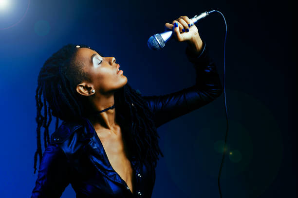 Cool profile portrait of a young singer holding microphone at concert stock photo