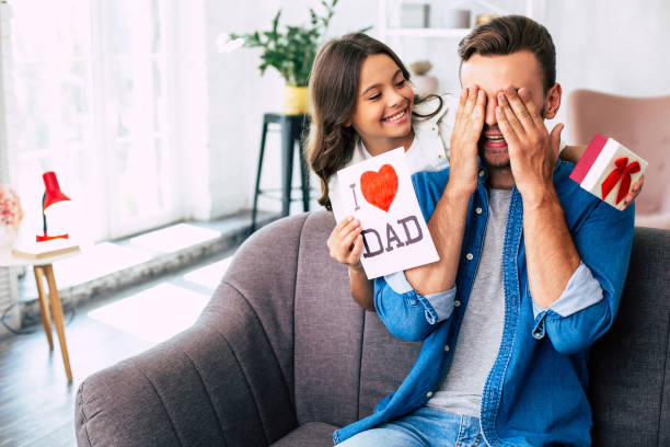Cool surprise from daughter. I love you, dad. Handsome young man at home with his little cute girl. Happy Father's Day! fathers day stock pictures, royalty-free photos & images