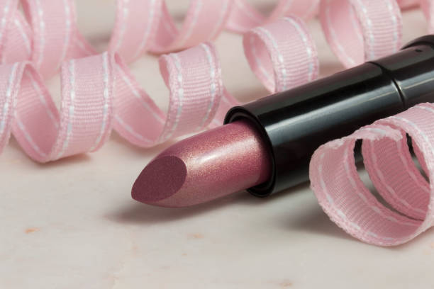 Copper pink lipstick with pastel ribbon curls stock photo