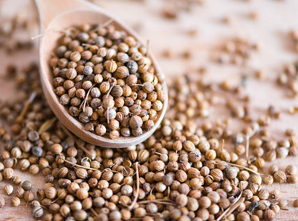 coriander seeds, close-up coriander seeds in wooden spoon, close-up   coriander seed stock pictures, royalty-free photos & images