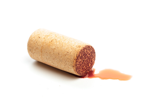 Cork with spilt red wine isolated on white