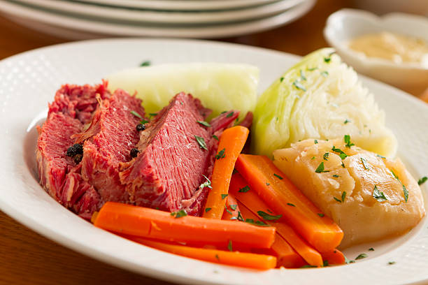 Corned beef, carrots, and onion on a white plate stock photo