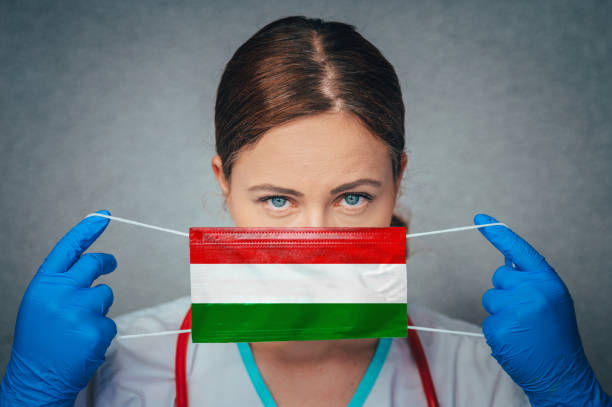 Coronavirus in Hungary Female Doctor Portrait hold protect Face surgical medical mask with Hungary National Flag. Illness, Virus Covid-19 in Hungary, concept photo Coronavirus in Hungary Female Doctor Portrait hold protect Face surgical medical mask with Hungary National Flag. Illness, Virus Covid-19 in Hungary, concept photo hungary stock pictures, royalty-free photos & images