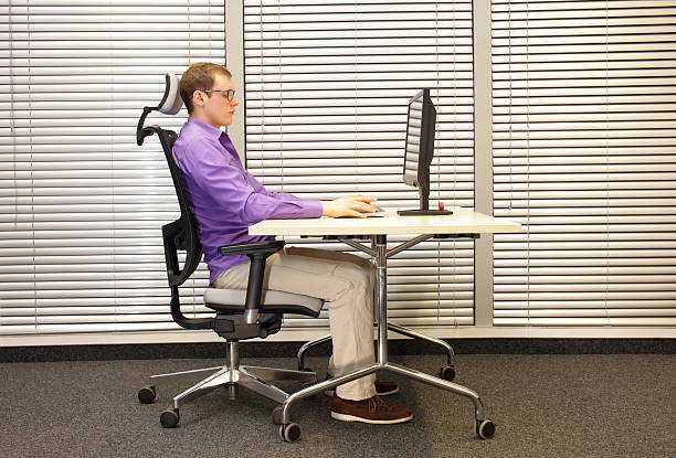 correct sitting position at workstation with computer stock photo