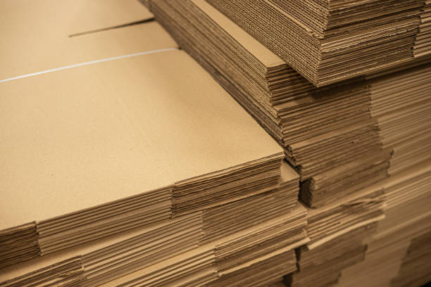 Corrugated fiberboard brown box paper cardboard folded pile stack in factory stock photo