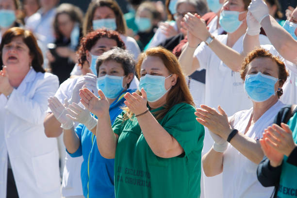 コルナ-スペイン.新しいコロナウイルス危機に対処する医療従事者が拍手を送る - 退院 ストックフォトと画像