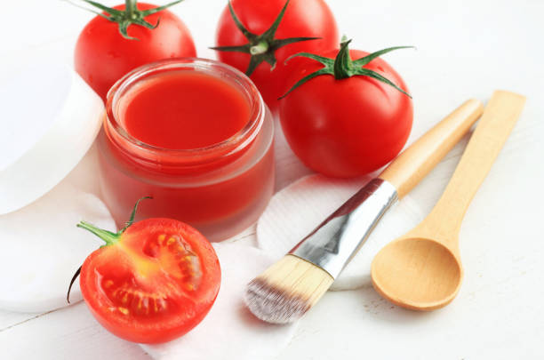 Cosmetic jar of facial homemade mask from bright red fresh ripe tomatoes, closeup. Organic natural body and beauty treatment. tomato face mask stock pictures, royalty-free photos & images