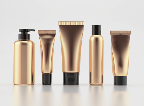 Bottles and tubes for cosmetics in pink gold with black caps on white background