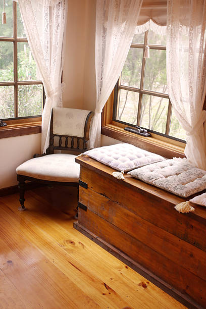 Cosy Corner Cosy corner of a Victorian style country cottage, with cushioned window seat, and 19th century chair. alcove window seat stock pictures, royalty-free photos & images