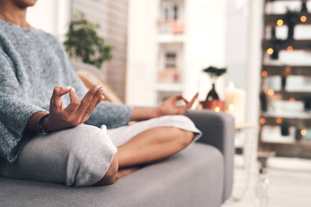 I could sit here all day Cropped shot of an unrecognizable woman sitting in a lotus position alone and meditating in her living room at home mental health awareness stock pictures, royalty-free photos & images