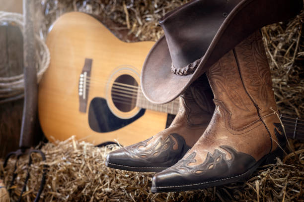 Country music festival live concert or rodeo with cowboy hat guitar and boots in barn stock photo