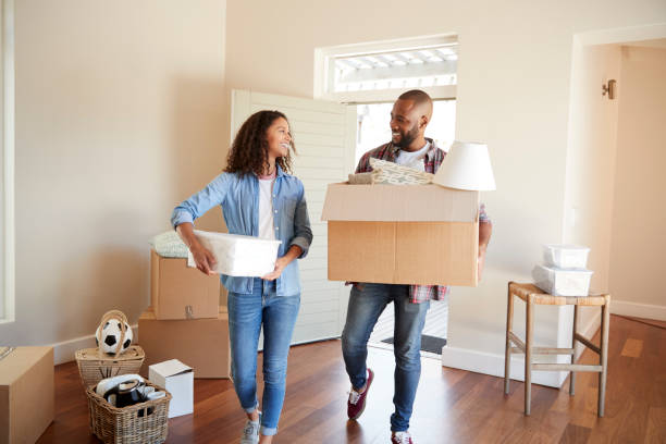 Couple Carrying Boxes Into New Home On Moving Day Couple Carrying Boxes Into New Home On Moving Day unpacking stock pictures, royalty-free photos & images