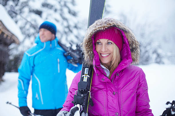 Couple carrying skis and poles in snow  lech valley stock pictures, royalty-free photos & images