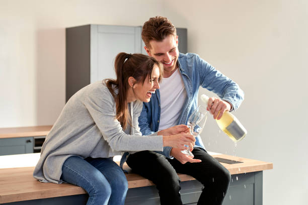 Couple celebrating house ownership with a champagne stock photo