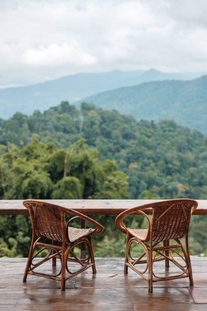 Couple chairs on balcony of countryside home or homestay with mountain view background in the morning stock photo