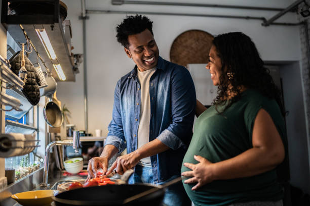 Couple cooking together at home Couple cooking together at home pregnancy after 40 stock pictures, royalty-free photos & images