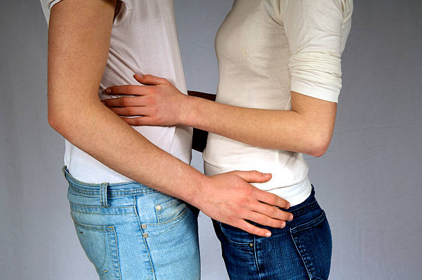 A couple embracing by their waists stock photo