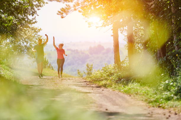 couple enjoying in a healthy lifestyle while jogging on a country road stock photo