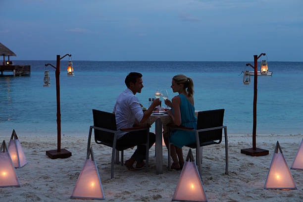 couple enjoying late meal in outdoor restaurant - sunset dining stockfoto's en -beelden