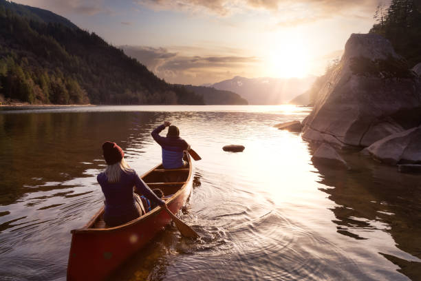 Couple friends canoeing on a wooden canoe stock photo