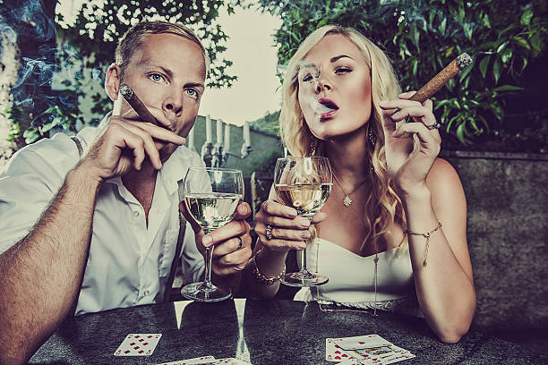 coppia avendo un drink e fumare sigari - sinner foto e immagini stock
