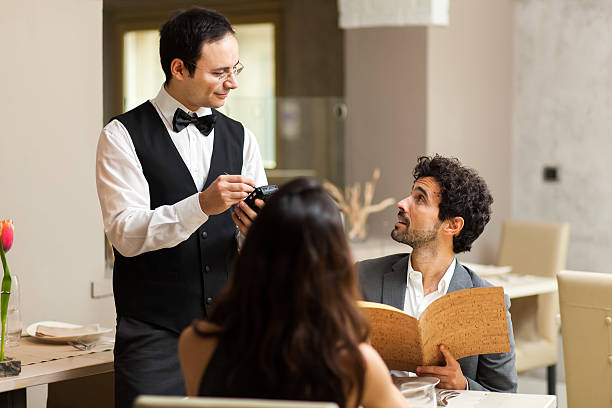 Couple having dinner in a luxury restaurant Couple having dinner in a luxury restaurant waiter taking order stock pictures, royalty-free photos & images