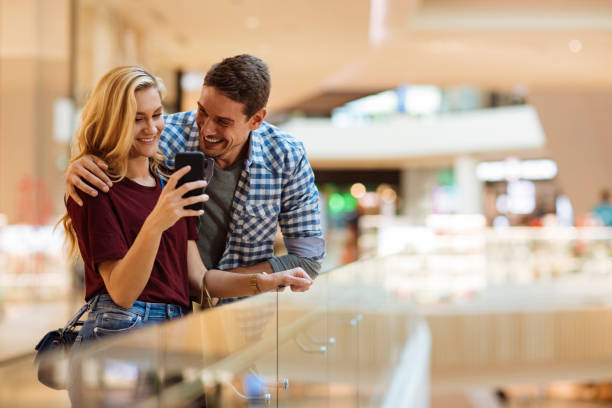 couple having fun in mall - boetiek stockfoto's en -beelden