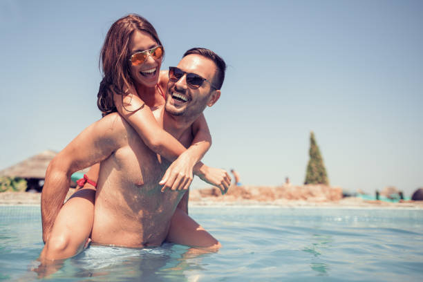 Couple having fun in swimming pool stock photo